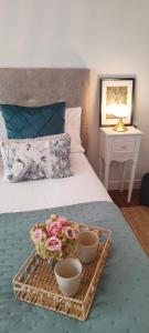 una bandeja con flores y dos cuencos en una cama en Fruela Centro- Parking gratuito, en Oviedo