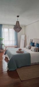 Un dormitorio con una cama grande y una lámpara de araña. en Fruela Centro- Parking gratuito, en Oviedo