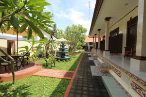 a courtyard of a building with benches and tables at Frangipani Homestay in Nusa Dua