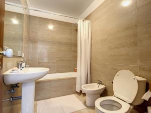 Un baño con inodoro, lavabo y bañera. en Amarelo Apartment by Atlantic Holiday, en São Vicente 34 fotos más