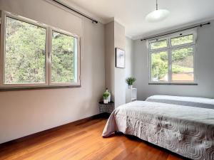 - une chambre avec un lit et 2 fenêtres dans l'établissement Amarelo Apartment by Atlantic Holiday, à São Vicente