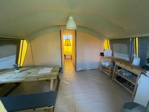 een kleine kamer met een houten tafel en een keuken bij Ingerichte De Waard tent - 5 personen in Beilen
