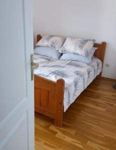 a bed with pillows on it in a room at Domaćinska kuća in Arandjelovac