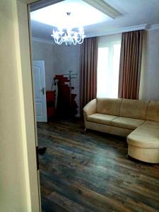 een woonkamer met een bank en een kroonluchter bij White House in Bălţi