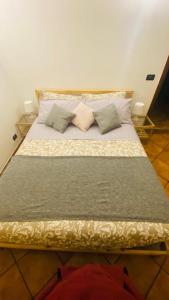 a large bed with four pillows on it at La casa tra gli ulivi di Fonte Nuova 1 in Fonte Nuova