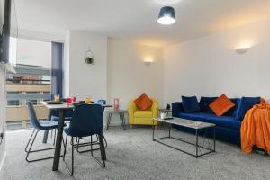 Home Away From Home - Contractors & Leisure في شيفيلد: غرفة معيشة مع أريكة زرقاء وطاولة