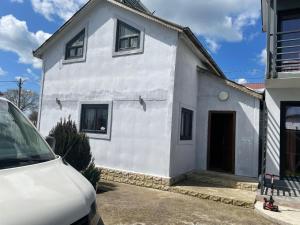 a white house with a car parked in front of it at Casa B&P in Costinesti