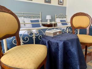 um quarto com 2 camas, uma mesa e cadeiras em Casa Verga em Siracusa