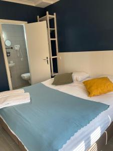 a bedroom with a large bed and a bathroom at Hotel HEB in Ostend