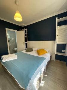 a bedroom with a large bed with a blue wall at Hotel HEB in Ostend