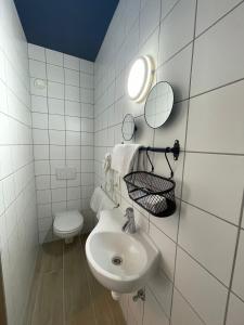een witte badkamer met een wastafel en een toilet bij Hotel HEB in Oostende