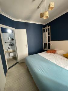 1 dormitorio con cama y pared azul en Hotel HEB, en Ostende