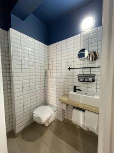 a white bathroom with a toilet and a sink at Hotel HEB in Ostend