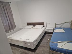 a bedroom with two beds and a window at Apartmani Biskup in Dugi Rat +6 photos
