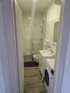 a bathroom with a sink and a washing machine at Apartmani Biskup in Dugi Rat