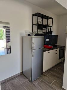 a kitchen with a stainless steel refrigerator in a room at Apartmani Biskup in Dugi Rat