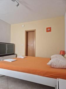 a bedroom with a large bed and a flat screen tv at Apartmani Biskup in Dugi Rat