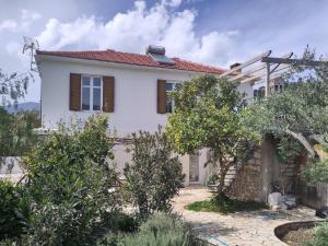 a white house with a garden in front of it at Metropolis Villa in Vathi, Ithaka