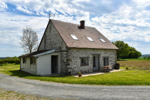 a small stone house with windows on the side of a road at Gite Un Le Terrail in Villard