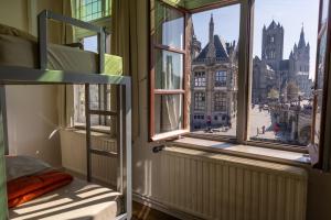 a room with two bunk beds and a window with a city view at Hostel Uppelink in Ghent