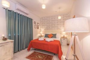 a bedroom with a bed with a red blanket and a lamp at Kikka B&B in Tarxien