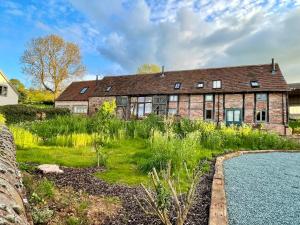 an old brick house with a garden and a swimming pool at The Forge - Beautiful Contemporary Barn - Hot Tub in Bridgnorth