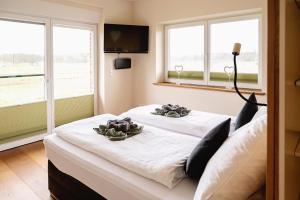 two beds in a room with two windows at HeiDeluxe Landhaus mit Sauna in Soltau