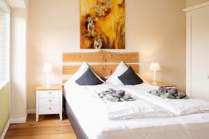 a bedroom with a white bed with two stuffed animals on it at HeiDeluxe Landhaus mit Sauna in Soltau