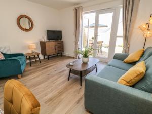 a living room with a blue couch and a table at Pebble Bay in Bideford
