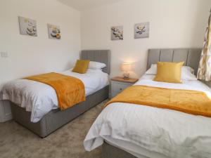 dwa łóżka siedzące obok siebie w sypialni w obiekcie Pebble Bay w mieście Bideford