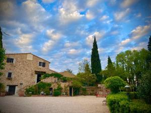 Darnius的住宿－Masia Mimosa Montaña，一座蓝色天空的石头大建筑