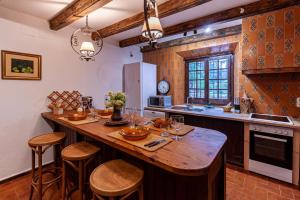 a kitchen with a large wooden island with stools at Masia Mimosa Montaña in Darnius