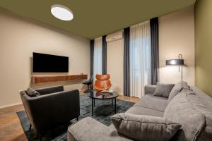 a living room with a couch and a tv at Green, deluxe two bedroom suite in Split