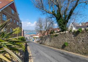 an empty street next to a stone wall at The Retreat 1 Alexandra Court in Swanage