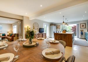a dining room and living room with a table and chairs at The Brackens in Langton Matravers