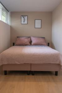 una camera da letto con un grande letto con cuscini rosa di 't Bunga huiske a Lanaken