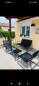 a patio with two black chairs and a table at Jimmy's Crib in Moudhros