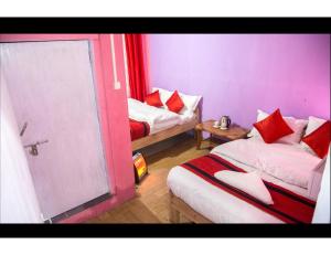 NātangにあるHill Home Stay, Baichungの赤い枕のベッド2台が備わる客室です。