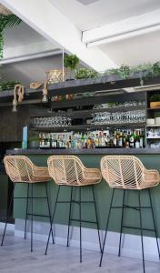 un bar avec des chaises en osier et un comptoir vert dans l'établissement Camping les Acacias, à Altkirch