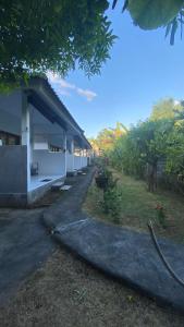 a white building with a roof and a yard at Murni house in Ambat