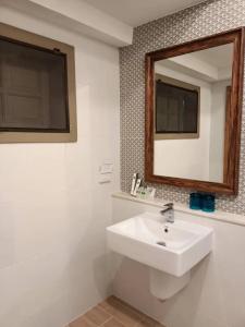ein Badezimmer mit einem weißen Waschbecken und einem Spiegel in der Unterkunft Lhongkhao Samoeng By Chivilla 