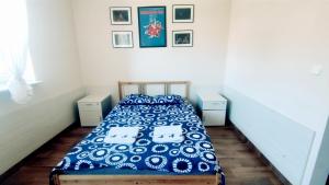 a bedroom with a bed with a blue and white comforter at Pokoje Gościnne Rozbark in Bytom