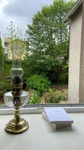 een glazen vaas en een boek op een vensterbank bij Chez Yann et Valérie in Pont-Aven