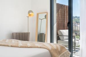 um quarto com uma cama, uma cadeira e um espelho em TSA La Rambla em Barcelona