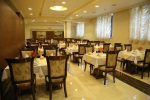 a dining room with tables and chairs in a restaurant at Royal Plaza by Stellar Hotels, Yerevan in Yerevan