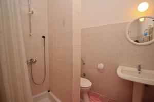 La salle de bains est pourvue d'une douche, de toilettes et d'un lavabo. dans l'établissement Apartman Nada, à Punat