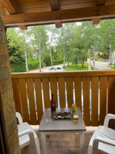 a table with a bottle of wine on a porch at Apartman AS in Zlatibor