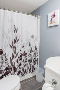 a bathroom with a shower curtain and a toilet at Centric Ranch in the South ave by Dwtn/UofR/Arpt in Rochester
