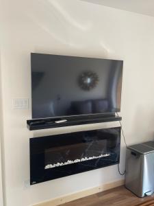 a fireplace with a flat screen tv on top of it at Evo Luxury Waterfront Adults Only B&B in Tobermory