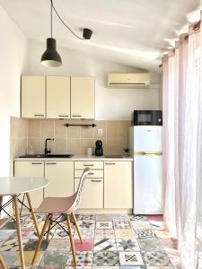 a kitchen with a table and a white refrigerator at Apartments Keko in Primošten